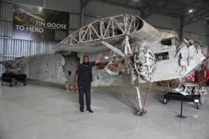 man standing beside an old airplane